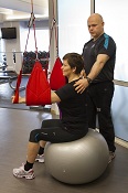 Personleg trenar med pasient på gymball med slyngetrening